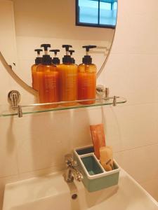 a bathroom sink with four bottles on a mirror at Elevated Bungalow House 5 min from the beach 3-6 in Nathon Bay +2 photos
