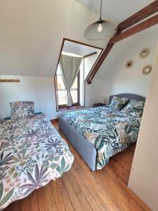 a bedroom with two beds and a window at Le Longbeach 1 in Longueville