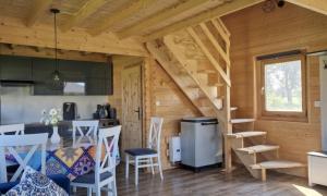 a kitchen and dining room of a log cabin at Domek wakacyjny Domysłów in Domysłów