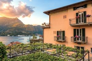 a building with balconies and a view of the water and mountains at Hotel Don Ferrante in Bellagio