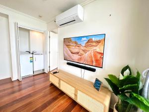 a living room with a flat screen tv on a wall at Prime CBD High Rise Apartment in Cairns
