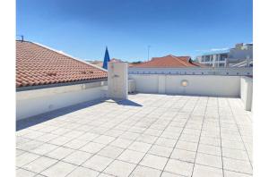 a large patio with a white wall and a roof at Misofi' in Bibione