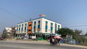 a building on the side of a street with a person on a bike at KH Residency And Lodging in Punganūru