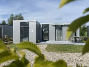 a modern house with a large glass door at Surf Osada, komfortowe domki w kameralnej okolicy nad samym brzegiem Zatoki Puckiej in Swarzewo