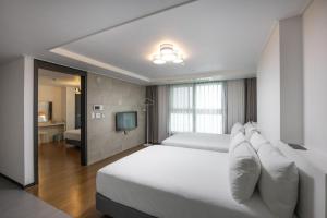 a large bedroom with two beds and a television at Ciel de Mer in Busan