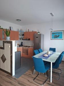 a kitchen with a table and some blue chairs at Enjoy in Omiš