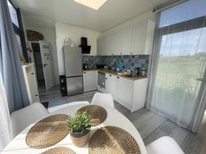 a kitchen with a table and chairs and a refrigerator at Surf Osada, komfortowe domki w kameralnej okolicy nad samym brzegiem Zatoki Puckiej in Swarzewo