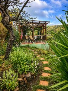 a garden with a wooden pergola and a patio at The Good Vibes Home in Hoya de Pineda