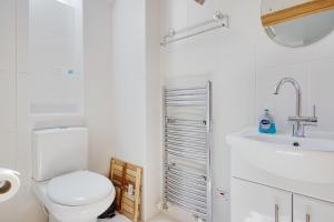 a white bathroom with a toilet and a sink at The Stables Hill Top Farm in Haselbury Bryan