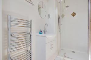 a white bathroom with a sink and a shower at The Stables Hill Top Farm in Haselbury Bryan