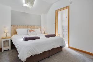 a bedroom with a large bed with two pillows on it at The Stables Hill Top Farm in Haselbury Bryan