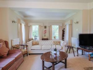 a living room with a couch and a table at Gould's Farmhouse in Blandford Forum