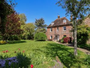 a large brick house with a green yard at Gould's Farmhouse in Blandford Forum