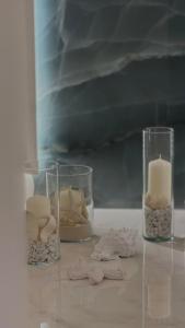 three glass vases with candles on a table at DuOr Suite & Rooms in Polignano a Mare +43 photos
