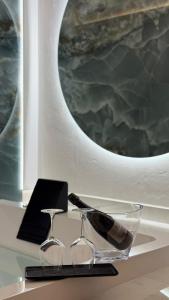 a pair of glasses on a table with a mirror at DuOr Suite & Rooms in Polignano a Mare