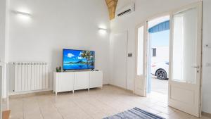 a living room with a television on a white cabinet at Corte Nizza in Taviano