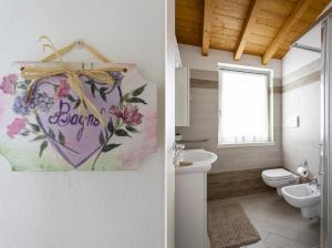 a bathroom with a toilet and a sign that says boobs at Albicocca in Tignale +25 photos