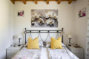 a bedroom with a bed and two yellow pillows at Albicocca in Tignale