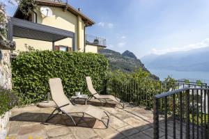 two chairs on a balcony with a view of the water at Albicocca in Tignale