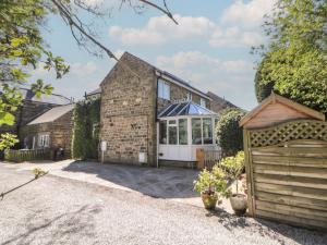 an exterior view of a brick house with a garage at Pine Cottage in Hathersage