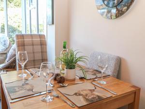 a wooden table with wine glasses on top of it at Pine Cottage in Hathersage