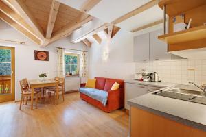 a kitchen and living room with a table and a couch at Getzenbergerhof in Chienes