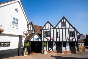 an old black and white building next to a white building at Best Western The Rose & Crown Hotel in Colchester