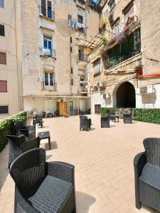 an empty courtyard with chairs and a building at MARVIT CENTRAL LUXURY in Naples