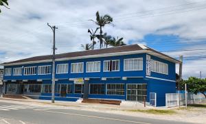 a blue building on the side of a street at Hotel Rainha in Itapoa