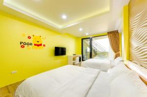 a bedroom with two beds and a yellow wall at 遇見龜山島 in Toucheng