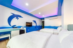 a bedroom with dolphins painted on the wall at 遇見龜山島 in Toucheng