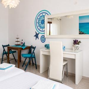 a bedroom with a desk and a table with chairs at Garden House in Hora Sfakion