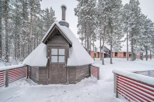 a small house with a snow covered roof in the snow at Wellevi Rooms by Aavalevi in Levi
