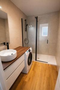 a bathroom with a sink and a washing machine at Winahost Madrid Towers II in Madrid