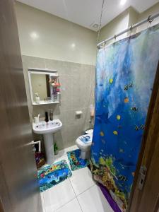a bathroom with a fish shower curtain and a sink at Duplex al menzah in Tamaris