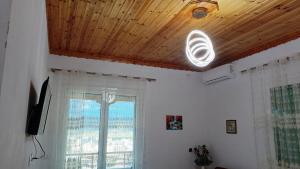 a living room with a wooden ceiling and a window at Amari Rooms in Gjirokastër