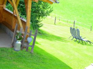two chairs and a fence in a yard with a house at Bauernhof König in Zwiesel +19 photos