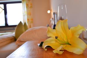 a yellow flower sitting on top of a wooden table at Bauernhof König in Zwiesel