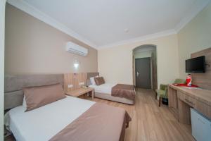 a hotel room with a bed and a television at Sava Hotel in Antalya