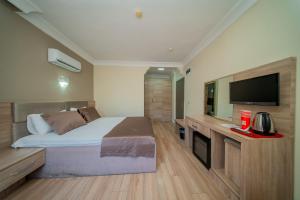 a bedroom with a bed and a flat screen tv at Sava Hotel in Antalya