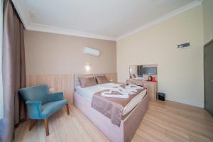 a bedroom with a bed and a blue chair at Sava Hotel in Antalya