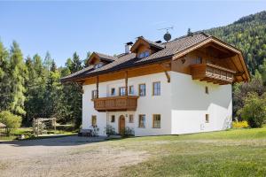 a large white house with a wooden roof at Getzenbergerhof in Chienes