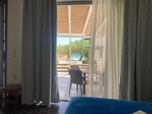 a bedroom with a bed and a window with a table at Agioi Apostoloi apartments in Agioi Apostoli