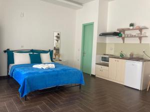 a bedroom with a blue bed and a kitchen at Agioi Apostoloi apartments in Agioi Apostoli +20 photos