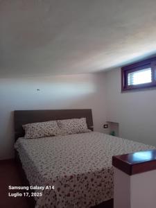 a bedroom with a bed and a window at Casa SILMAGA in La Maddalena