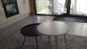 a white table and two stools in a room at L'Insolite in Melun
