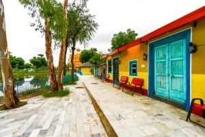 a row of colorful buildings next to a canal at Hotel Goram Garh Resort in Pāli