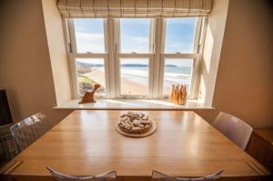 a dining room table with a view of the ocean at Hartland Heights in Woolacombe +26 photos