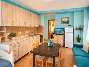 a kitchen with a table and a couch and a refrigerator at Sea view apartment 1 in Shëngjin