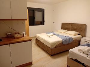 a room with two beds and a counter and a kitchen at Apartmani Edi Premium in Ulcinj